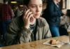 Pagar 100€ por un móvil que solo llama: Los «Dumbphones» son el nuevo capricho pijo de 2026 nfluencer Gen Z usando un dumbphone o móvil de tapa antiguo en una cafetería de moda.