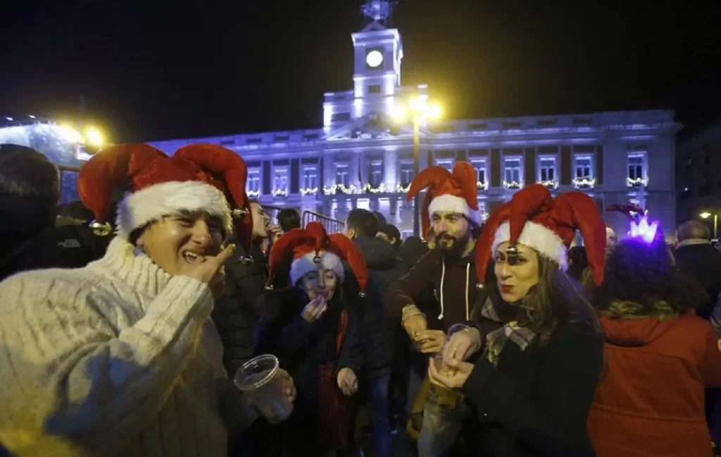 Gente comiéndose las 12 uvas de año nuevo en la puerta del sol
